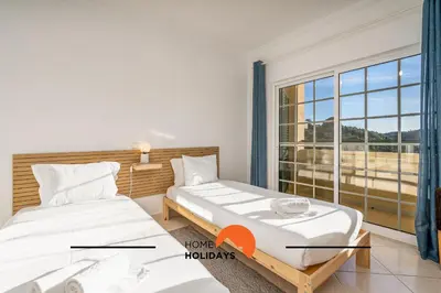 two beds in a room with a window at #257 Villa Sun & Sea by Home Holidays in Albufeira