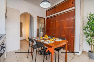 a dining room with a wooden table and chairs at #253 Fernando Pessoa 28 by Home Holidays in Albufeira