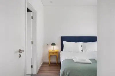 a bedroom with a bed and a side table at Faro Nony Apartment by Get Your Stay in Faro