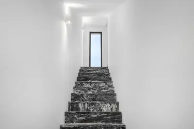 a stairway in a white room with a stone wall at Faro Nony Apartment by Get Your Stay in Faro