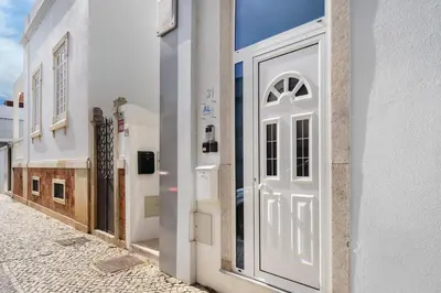 a white door on the side of a building at Faro Nony Apartment by Get Your Stay in Faro