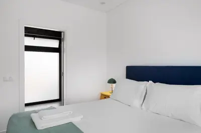 a bedroom with a white bed and a window at Faro Nony Apartment by Get Your Stay in Faro
