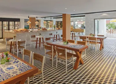 a restaurant with tables and chairs and a bar at Viceroy Residences at Ombria Algarve in Loulé