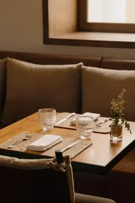 a table with glasses and napkins on a table with a couch at Viceroy Residences at Ombria Algarve in Loulé