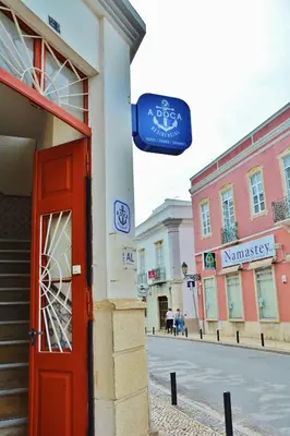 a building with a red door on the side of a street at Residencial A Doca in Faro