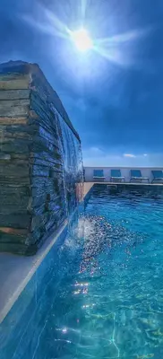 a swimming pool with blue chairs and a house at The View House in Albufeira