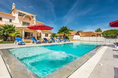 a swimming pool in front of a house at Villa Dourado in Boliqueime