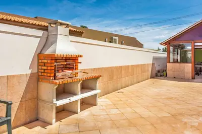 a patio with a brick oven on the side of a house at Villa Dourado in Boliqueime