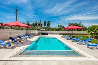 a swimming pool with chairs and umbrellas at Villa Dourado in Boliqueime