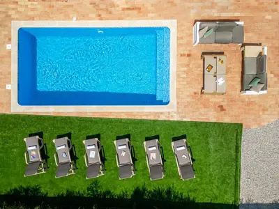 an overhead view of a group of chairs next to a swimming pool at Villa Bellegarde by Algarve Vacation in Albufeira