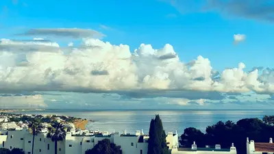 a view of a city and the ocean with clouds at SeaView apartment by MOJE Holiday in Albufeira