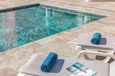 a pool with two lounge chairs and a swimming pool at Villa Sunny Joy by Algarve Vacation in Albufeira