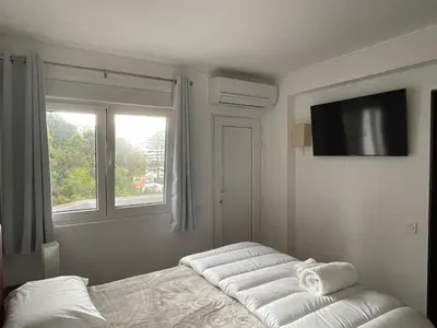 a white room with two beds and a window at OuraSea Apartment in Albufeira