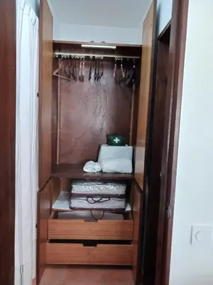 a walk in closet with wooden cabinets and towels at OuraSea Apartment in Albufeira