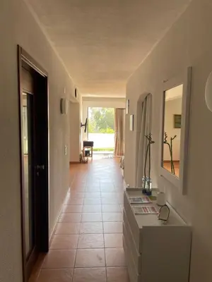 a hallway with a tile floor and a room with a mirror at OuraSea Apartment in Albufeira