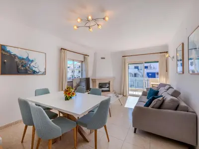 a swimming pool with two chairs and palm trees at Apartment Valmangude Sunny Escape - VIP Properties by Interhome in Albufeira