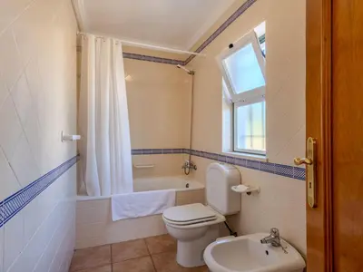 a bedroom with a bed with two brown towels on it at Holiday Home V3 Aguia M - VIP Properties by Interhome in Albufeira