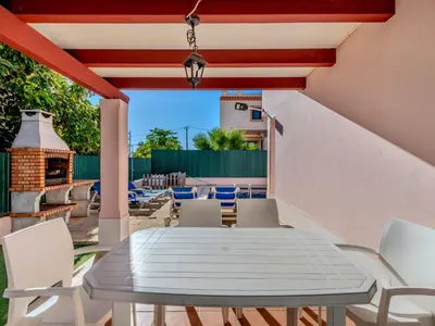 a table and chairs on a patio with a fireplace at Holiday Home V3 Aguia M - VIP Properties by Interhome in Albufeira