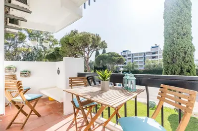 a patio with a wooden table and chairs at Appartement Algarve,Quarteira Vilamoura Lago Azul in Vilamoura