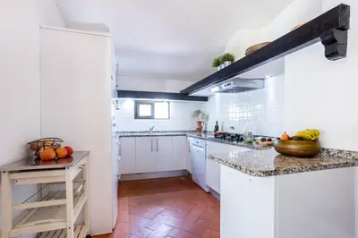 a kitchen with white cabinets and marble counter tops at Villa Bonita in Albufeira
