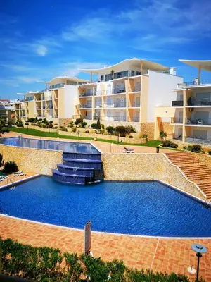 a swimming pool with a fountain in front of a building at Sea View Penthouse in Albufeira in Albufeira