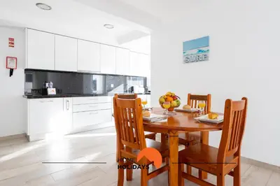 a kitchen with a wooden table and chairs at #089 Largo Escola by Home Holidays in Albufeira