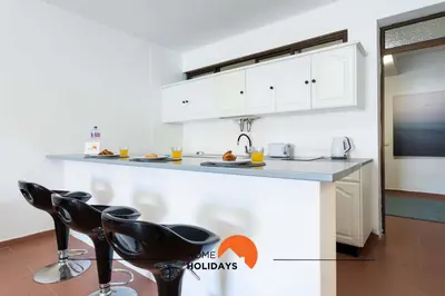 a plate with a glass of orange juice and a bowl of fruit at #170 Casa do Páteo I com Alpendre by Home Holidays in Albufeira
