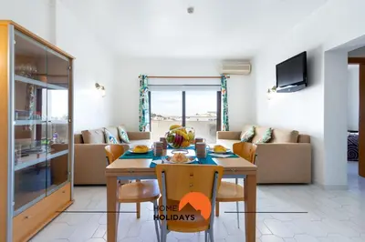 a living room with a table and a couch at #191 Smile Apartment by Home Holidays in Albufeira