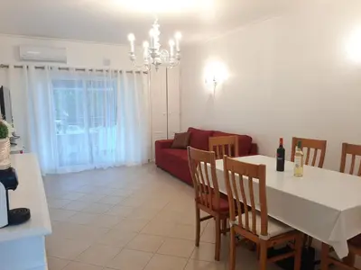 a living room with a red couch and a table at Beach Falésia in Albufeira