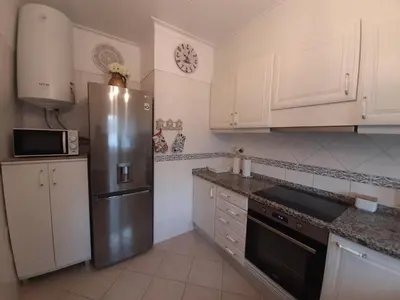 a kitchen with white cabinets and a sink and a dishwasher at Beach Falésia in Albufeira