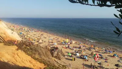 an apartment building with white balconies and a tree at Beach Falésia in Albufeira