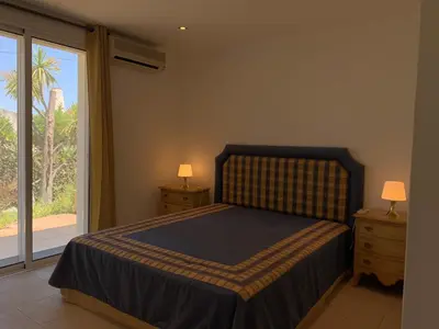 a bedroom with a bed and a large window at Villa Sofia in Almancil