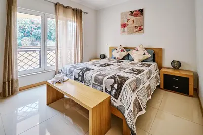 a bedroom with a bed with a table and a window at Apartment Sol de Verão mit Pool in Guia