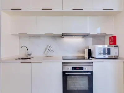 a kitchen with white cabinets and a microwave at Noah House, 2 bdr apartment with sea view in Quarteira