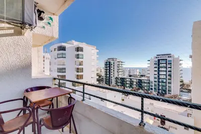 a balcony with a table and chairs and a view of buildings at Noah House, 2 bdr apartment with sea view in Quarteira