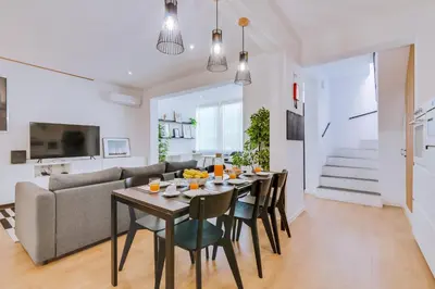 a dining room and living room with a table and chairs at Apartment with Rooftop and work space in Quarteira in Quarteira