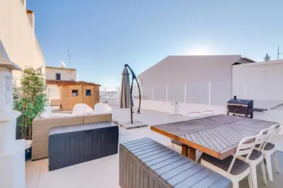a patio with a table and chairs on a roof at Apartment with Rooftop and work space in Quarteira in Quarteira