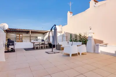a patio with white furniture and a table and chairs at Apartment with Rooftop and work space in Quarteira in Quarteira