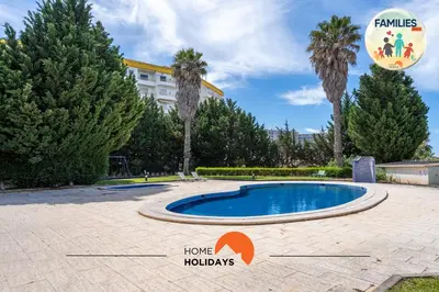 a swimming pool in a park with palm trees at #230 Only Families - Flat A Flor by Home Holidays in Albufeira