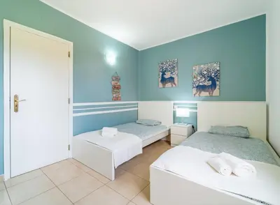 two beds in a room with blue walls at Villa Vilamoura NATURE GREEN GOLF AND POOL in Quarteira