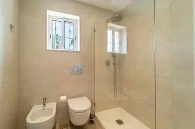 a bathroom with a toilet and a glass shower at Villa Vilamoura NATURE GREEN GOLF AND POOL in Quarteira