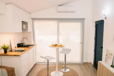 a kitchen with a table and two stools at Studio LUMINEUX et CALME à Vilamoura in Quarteira