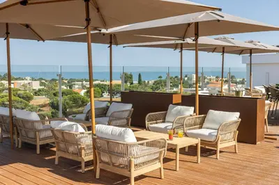 a wooden table with two cocktails on top of it at Castelo Suites Hotel in Albufeira