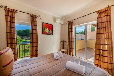 a bedroom with a large bed and a balcony at Vilamouratenis Monet by SAPvillas in Vilamoura