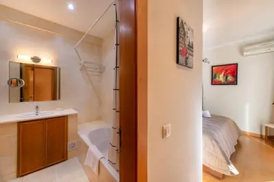 a bathroom with a bed and a sink and a tub at Vilamouratenis Monet by SAPvillas in Vilamoura
