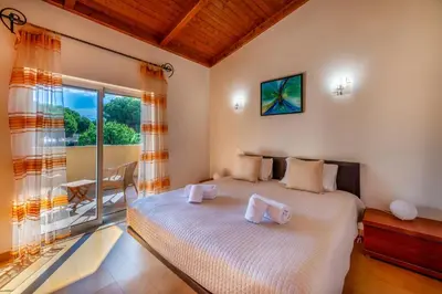 a bedroom with a bed and a large window at Vilamouratenis Monet by SAPvillas in Vilamoura