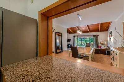 a dining room and living room with a dining table at Vilamouratenis Monet by SAPvillas in Vilamoura