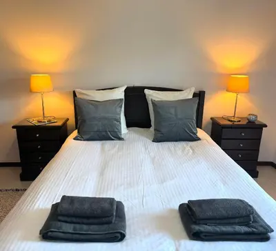 a bedroom with a bed with two towels on it at Aqua Plaza 2 Bedr swimming pool 5 min to the beach in Olhos de Água