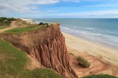 a large cliff next to a beach with the ocean at Aqua Plaza 2 Bedr swimming pool 5 min to the beach in Olhos de Água