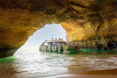 a boat in the water in front of a cave at Oldtown Starfish Beach House 2 min to the beach Wifi in Albufeira